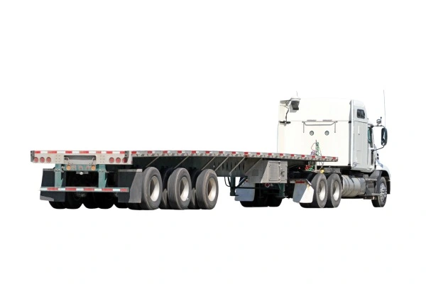 A white flatbed semi-truck with a long, empty trailer designed for carrying oversized loads or machinery. The truck is shown from a side angle, highlighting its numerous wheels and the flatbed structure, against a white background with no visible company markings or logos.